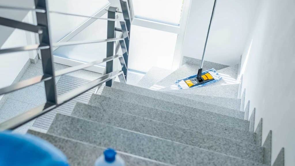 Frisch gewischtes Treppenhaus mit Reinigungsutensilien