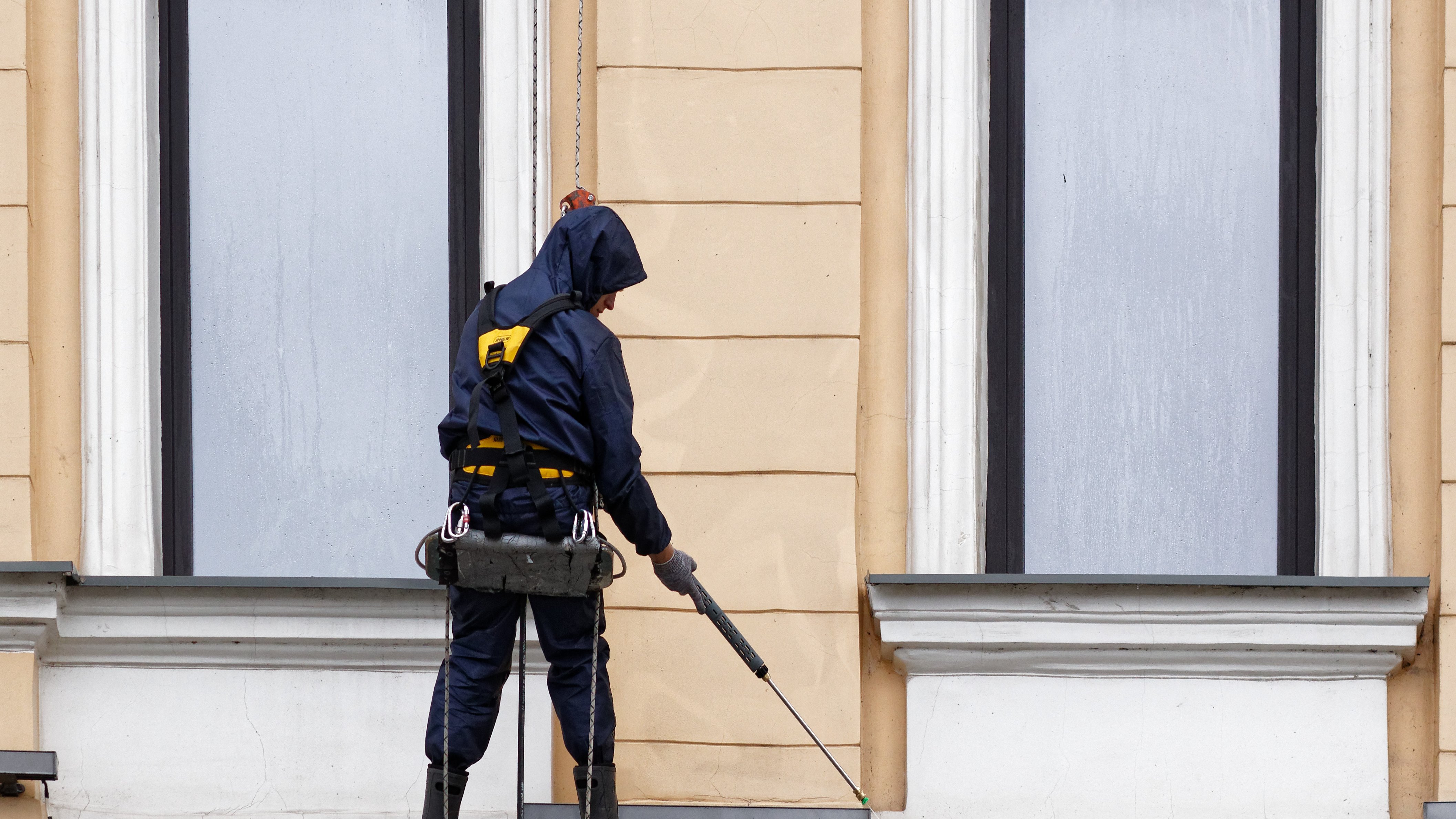 Fassadenreinigung Mitarbeiter reinigt seilgesichert die Fassade eines historischen Gebäudes