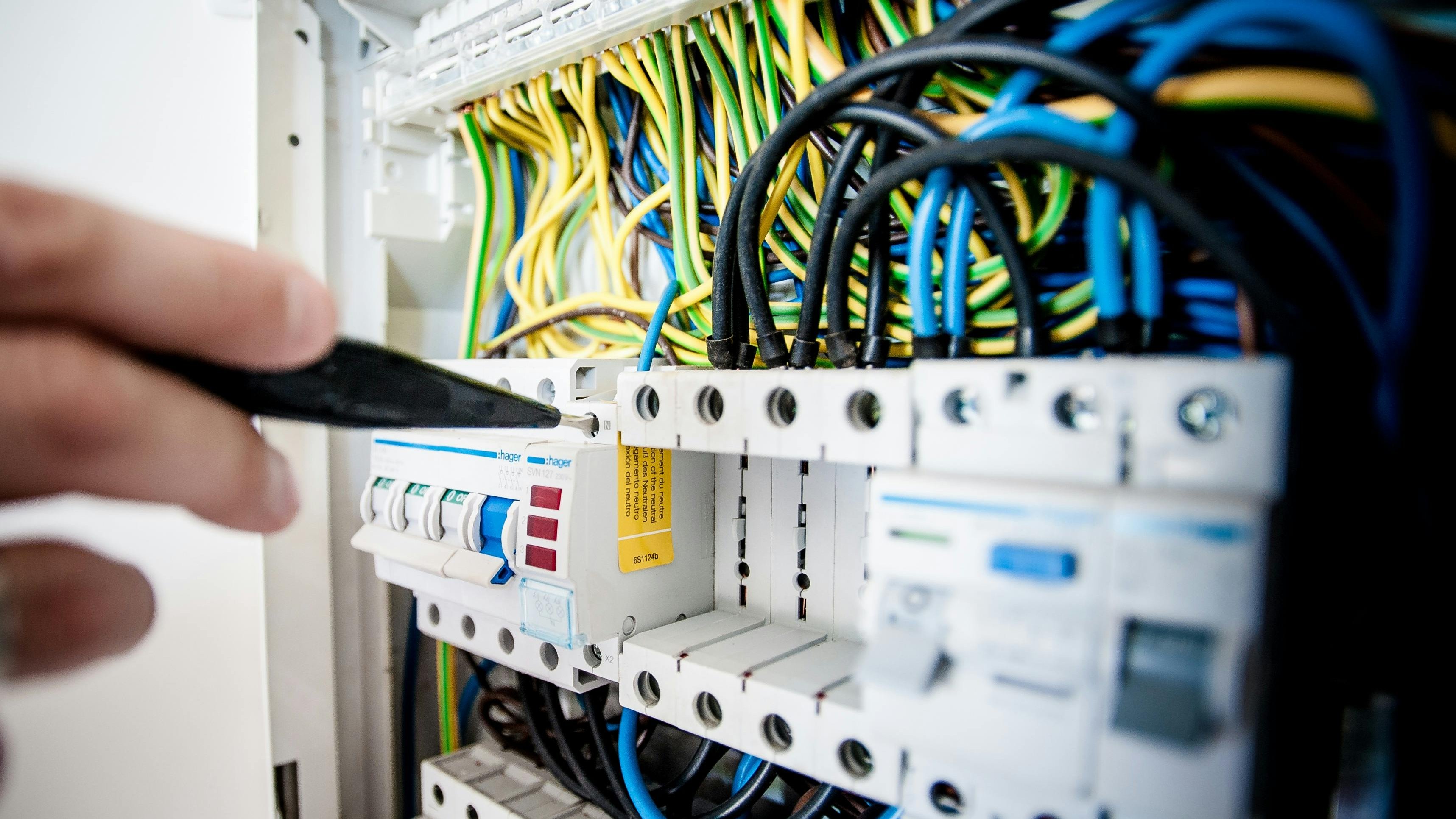 Techniker arbeitet an den Sicherungen eines Elektroverteilers