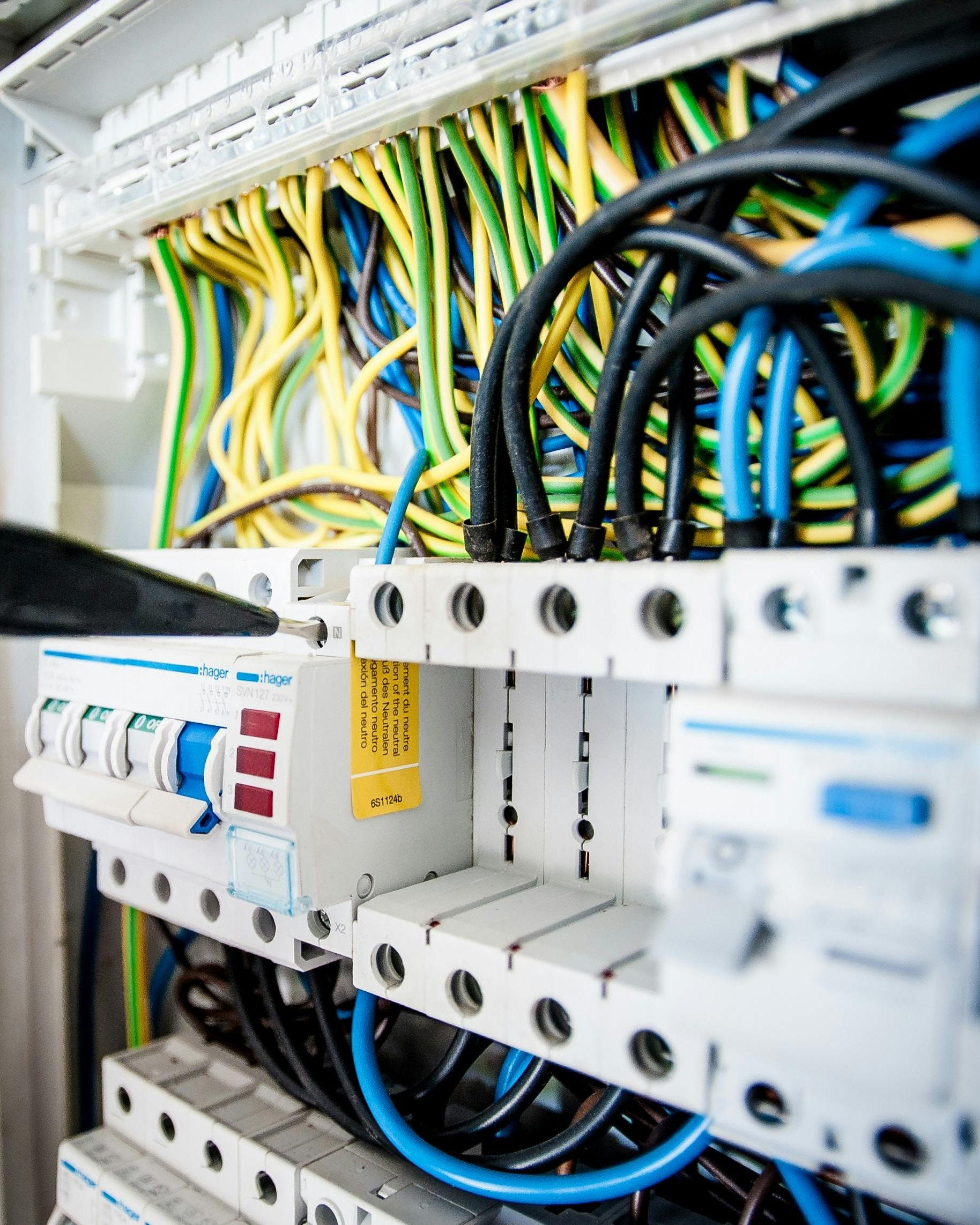Techniker arbeitet an den Sicherungen eines Elektroverteilers